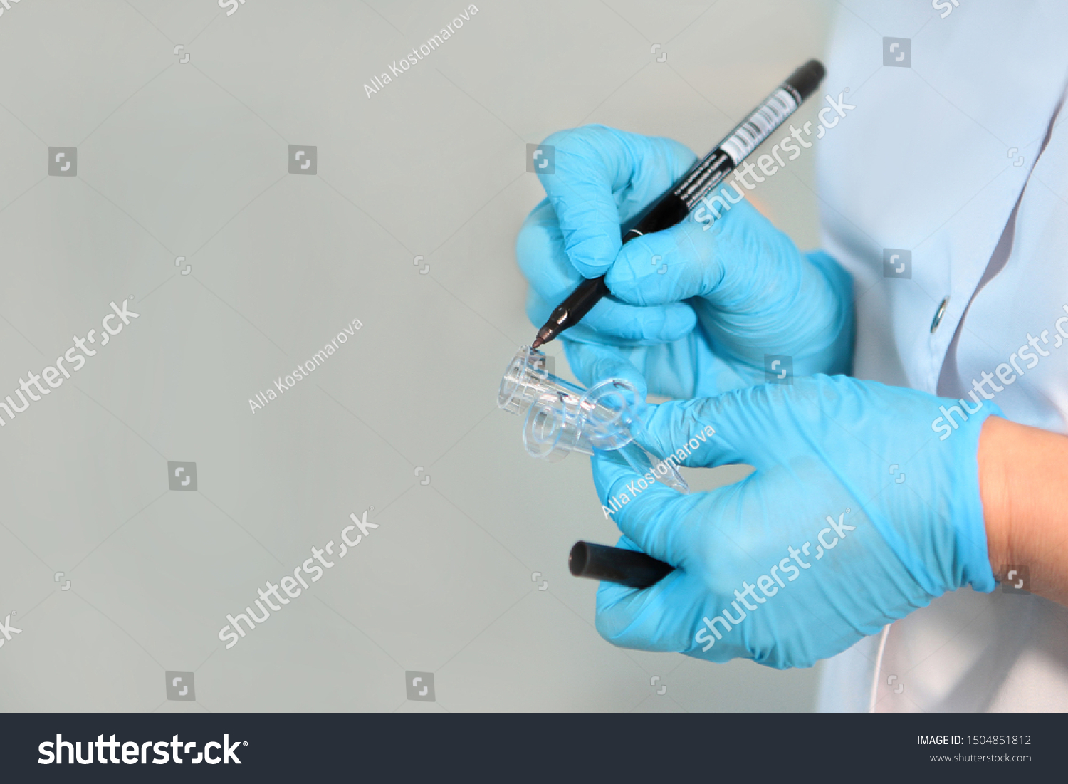 Close-up laboratory assistant hands with marker and test tube. Life saving concept. Photo in the interior. Macro photo. Copy space. #1504851812