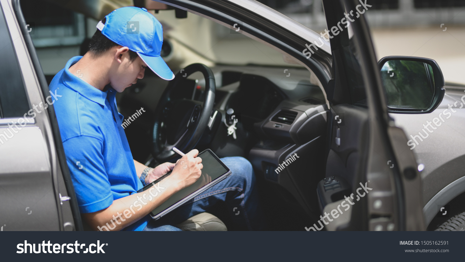 Young delivery man checking the products to customer with tablet while sitting on the car #1505162591