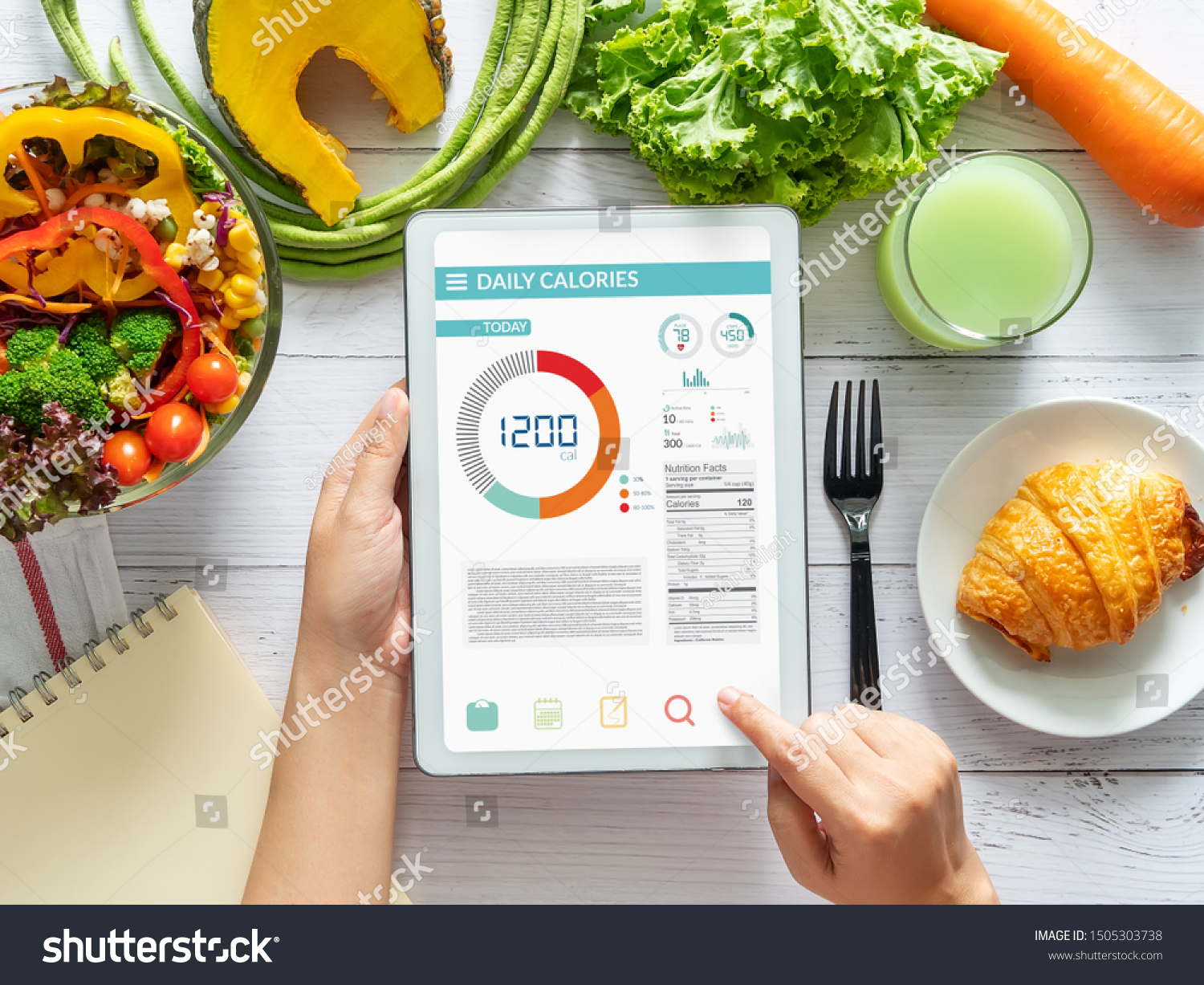 Calories counting , diet , food control and weight loss concept. woman using Calorie counter application on tablet at dining table with fresh vegetable salad #1505303738