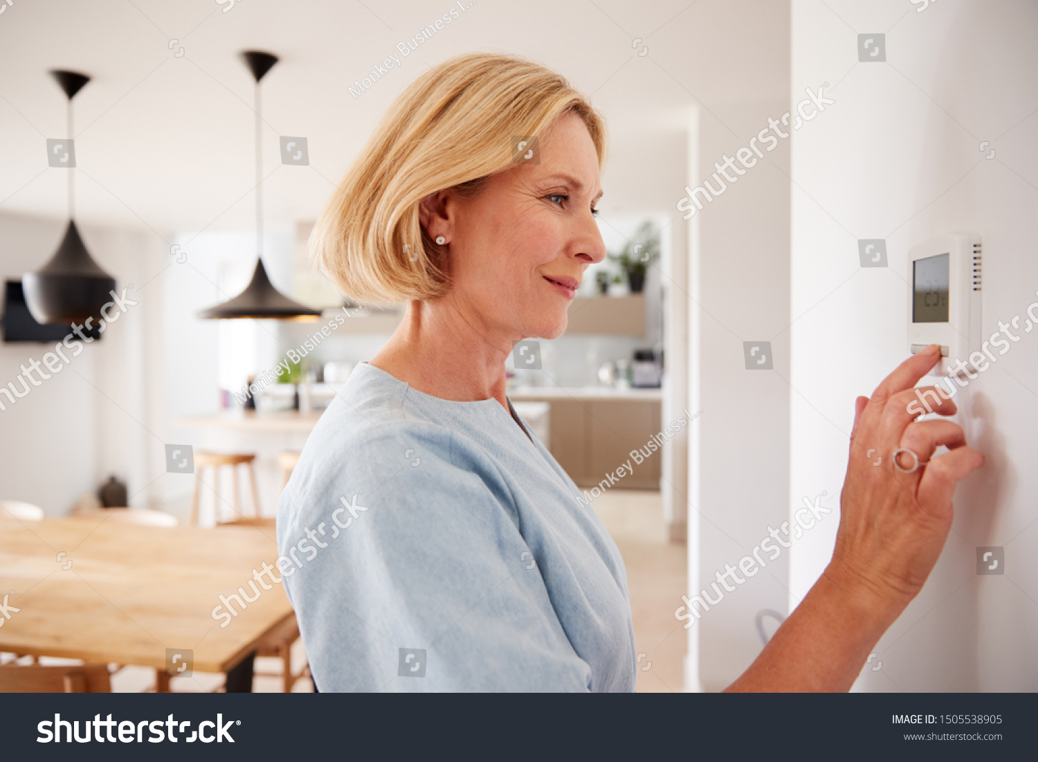 Close Up Of Mature Woman Adjusting Central Heating Temperature At Home On Thermostat #1505538905