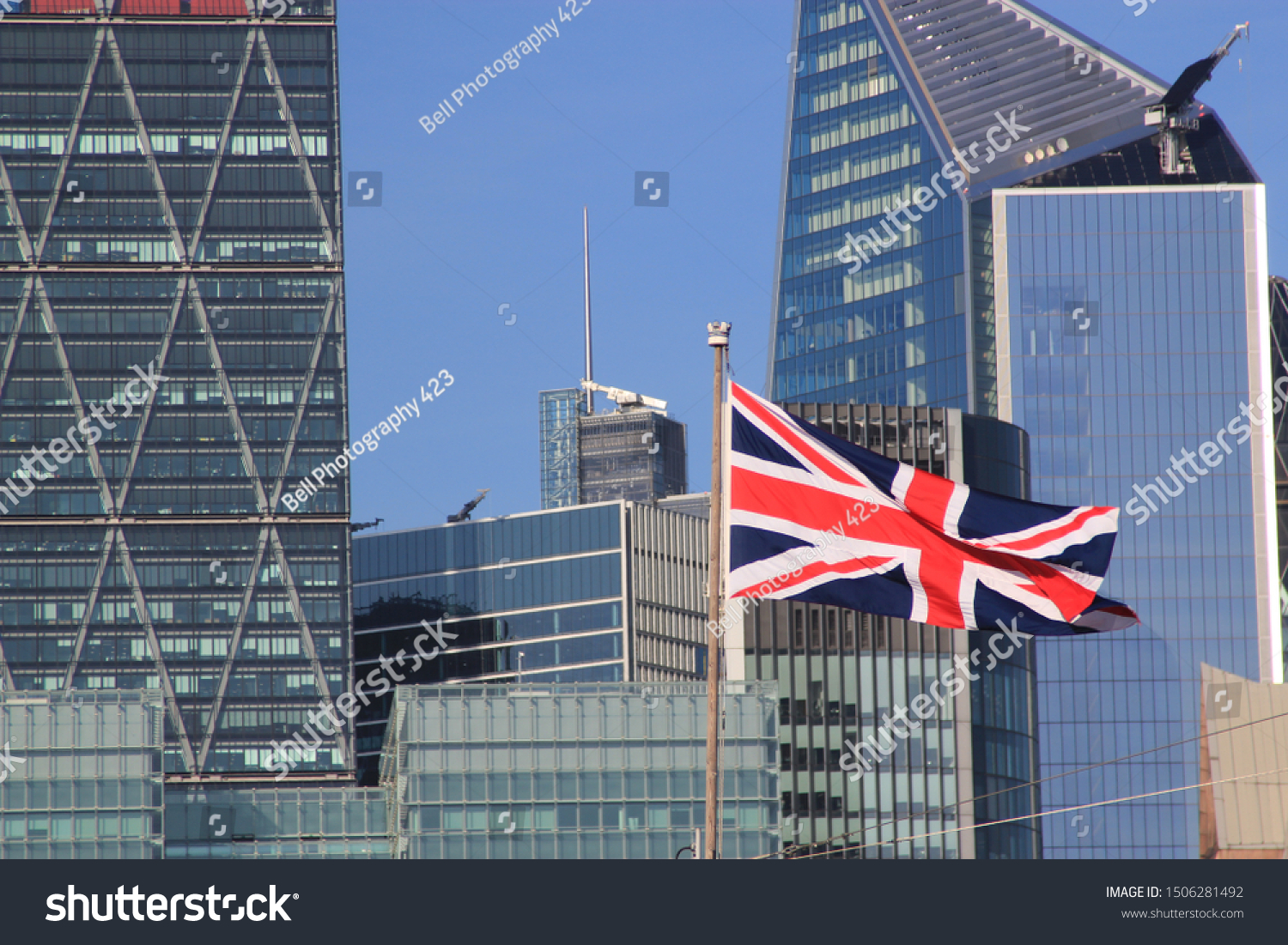 Union Jack flag flying in front of the modern buildings of the City of London designating Brexit and the London financial centre #1506281492