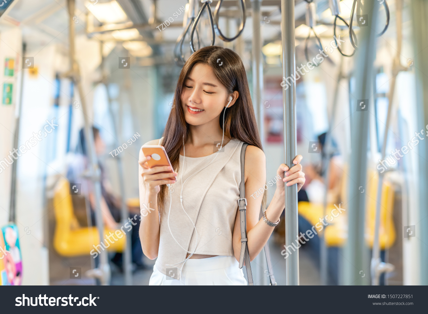 Young Asian woman passenger listening music via smart mobile phone in subway train when traveling in big city,japanese,chinese,Korean lifestyle and daily life, commuter and transportation concept #1507227851
