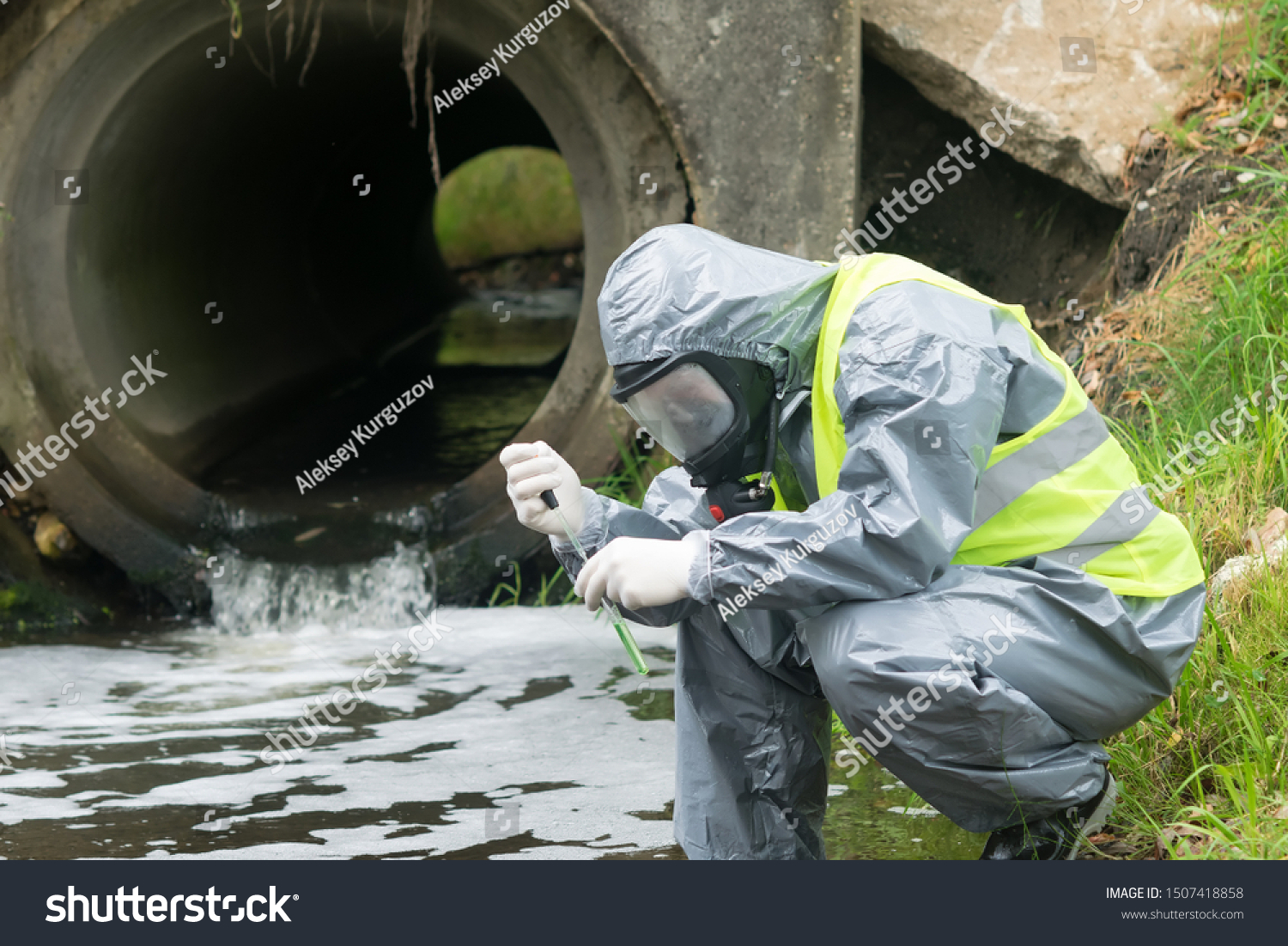 a man in a protective suit takes a sample of water from the river after the release of chemical waste #1507418858