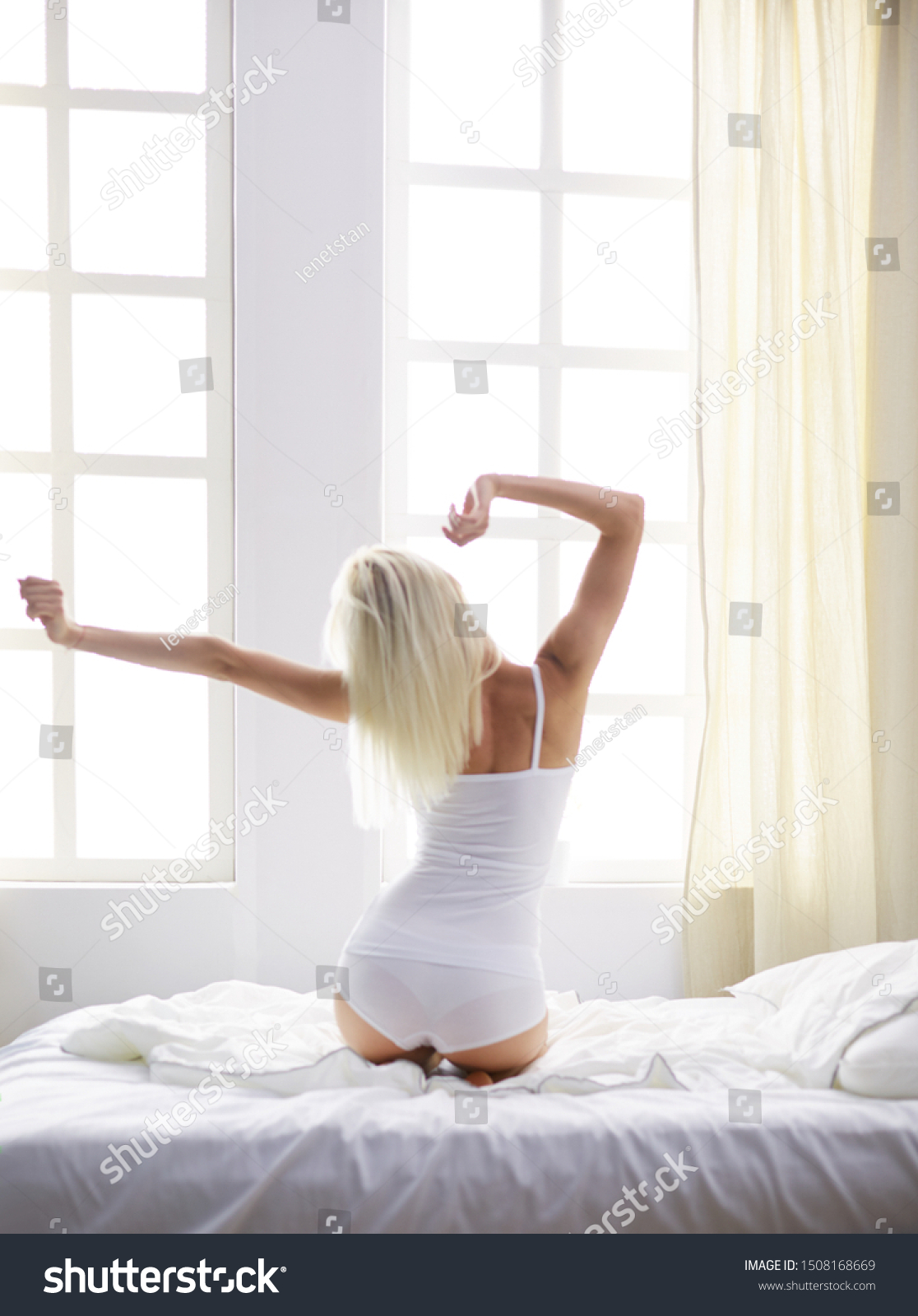 Woman stretching in bed after wake up, back view #1508168669