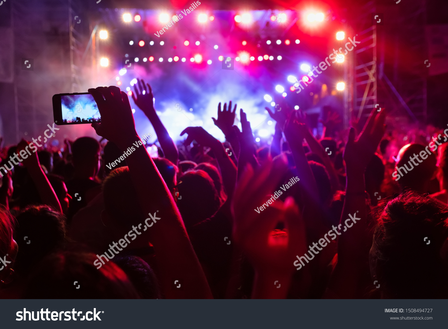 People taking photographs with smart phone during a public music concert #1508494727