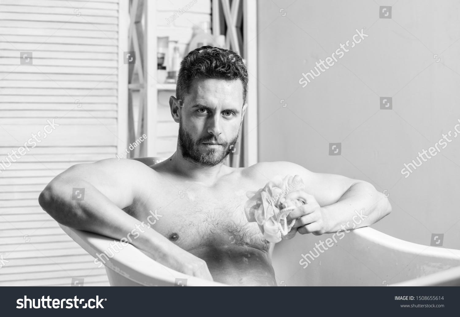 man wash muscular body with foam sponge. Macho attractive nude guy. Sexy man in bathroom. Wash off foam with water carefully. Sex and relaxation concept. Macho naked in bathtub. Sexy reality. #1508655614