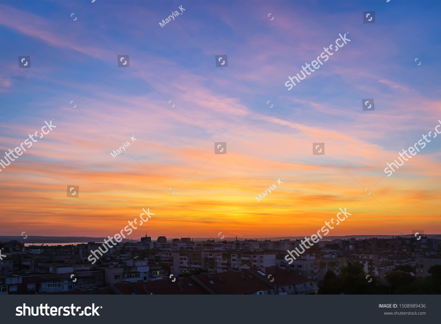 Beautiful skyscape at the sunset time over a small city. Vivid sky of golden and orange colors during sundown. Evening landscape. Beauty in nature. #1508989436