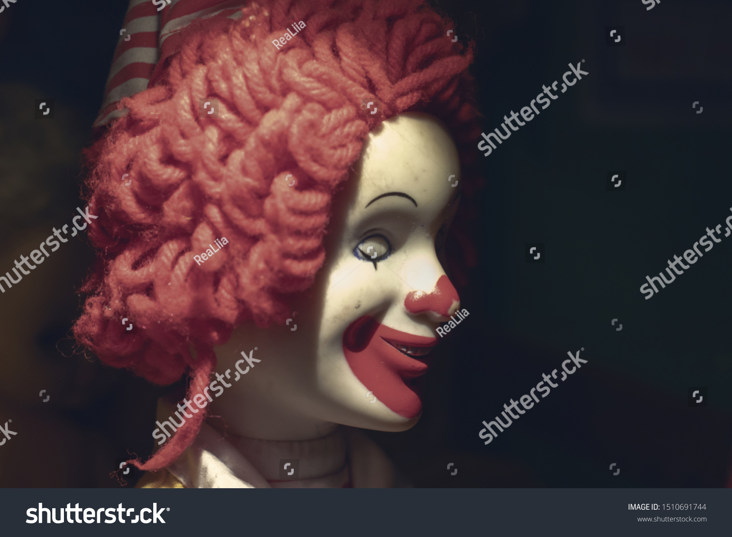 Scary evil sinister clown face with a spooky smile on black background with copy space, coulrophobia and fears concept. #1510691744