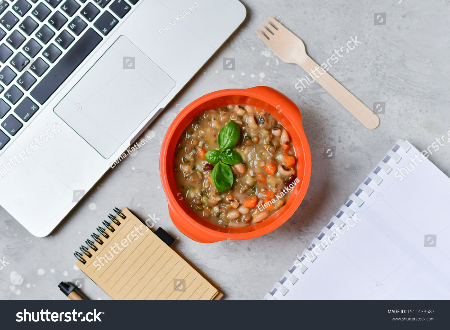 Food delivery. Round lunch box with a diet lunch or dinner on grey office table. Stewed beans with vegetables, takeaway lunch at the office. Top view. takeout healthy lunch. selective focus #1511433587