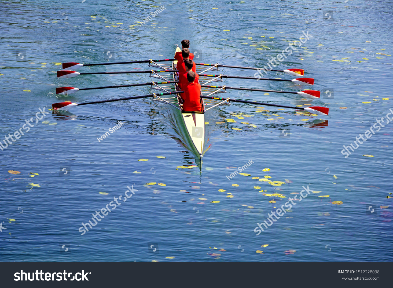 Men's quadruple rowing team on blue water, top view #1512228038