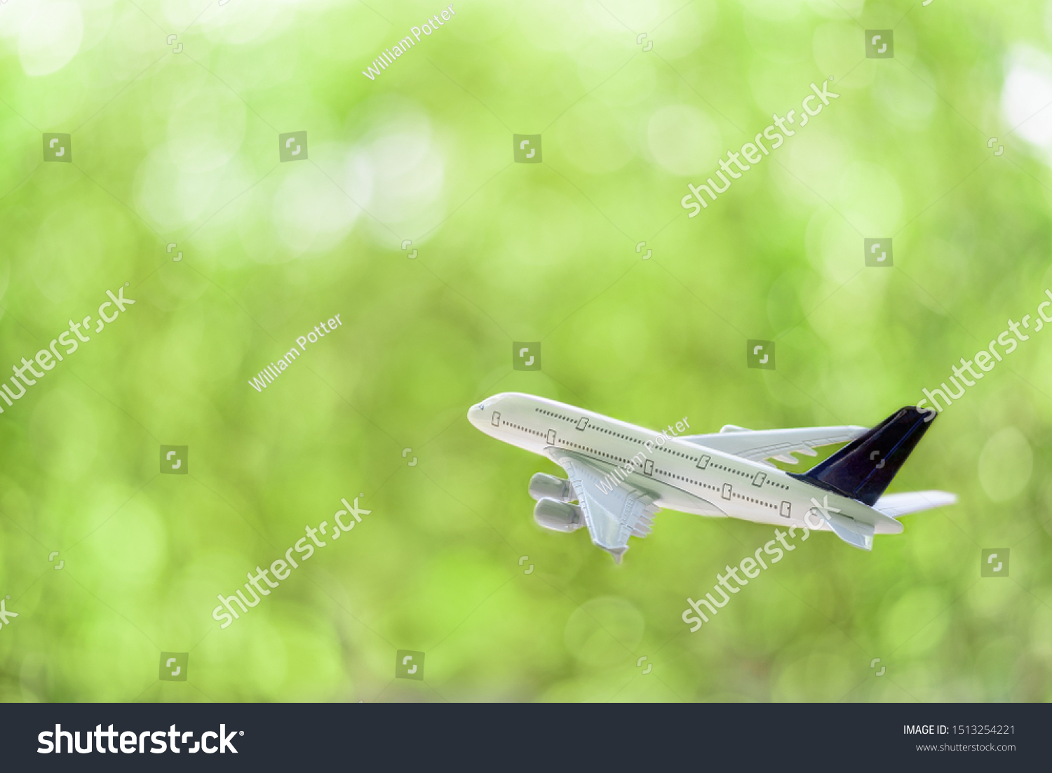 Freight forwarder, shipping courier agent service, aviation concept : White comercial plane / airplane fly over a green bokeh background, depict transporting of goods or parcel to overseas destination #1513254221