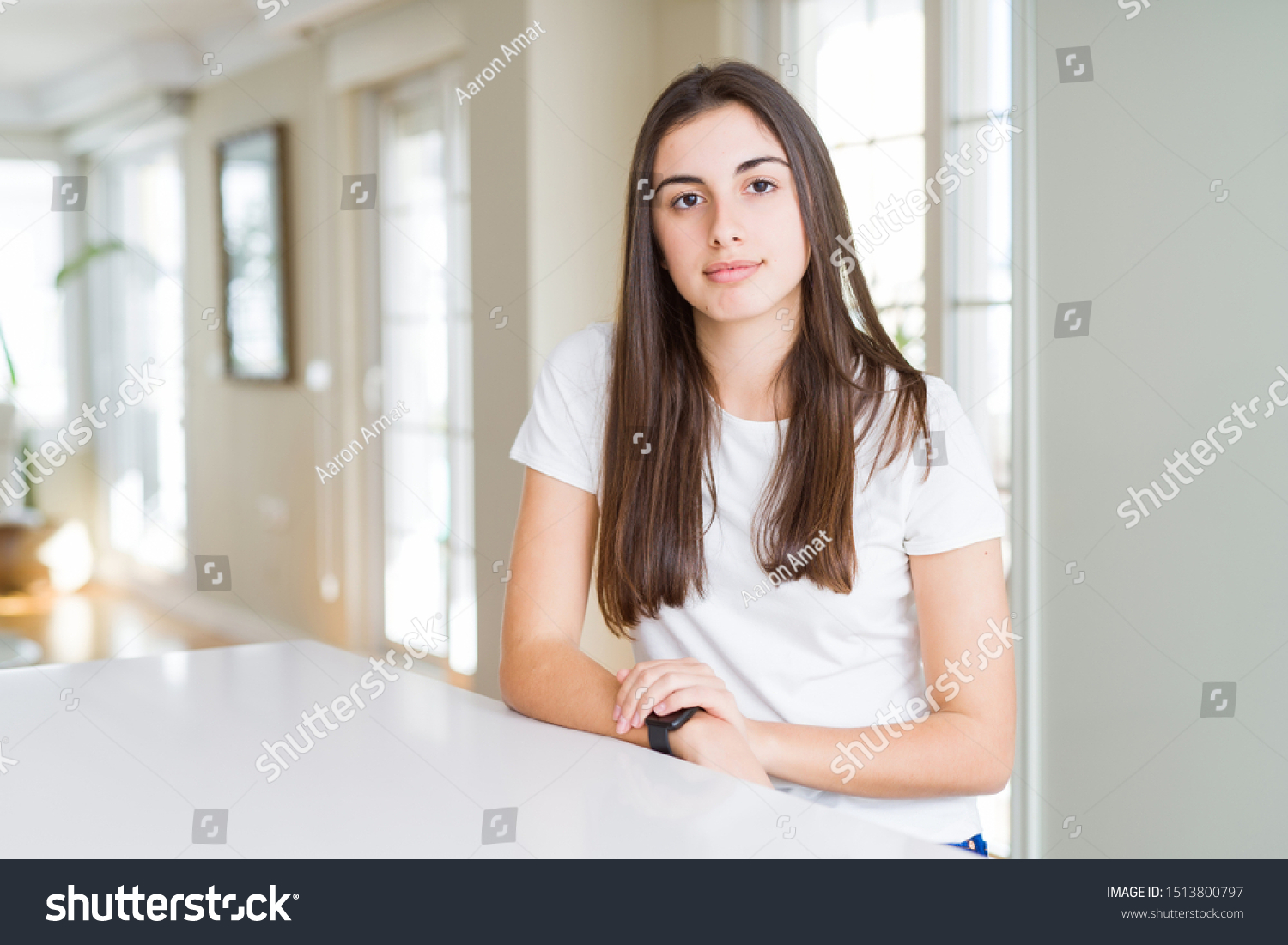 Beautiful young woman wearing casual white t-shirt with serious expression on face. Simple and natural looking at the camera. #1513800797