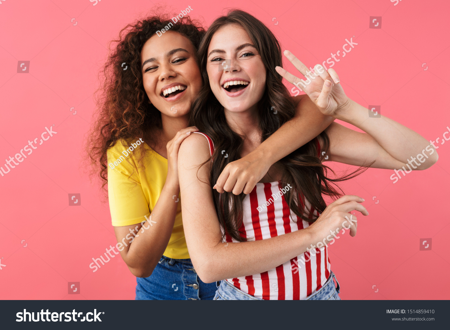 Image of happy multinational girls hugging and showing peace sign isolated over pink background #1514859410