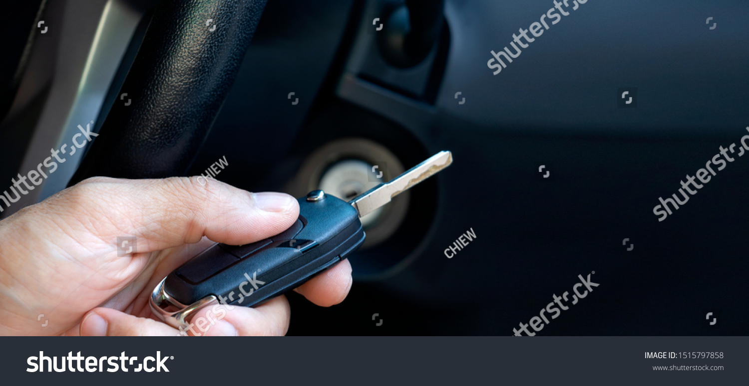 Closeup inside vehicle of hand holding key in ignition, start engine key. #1515797858