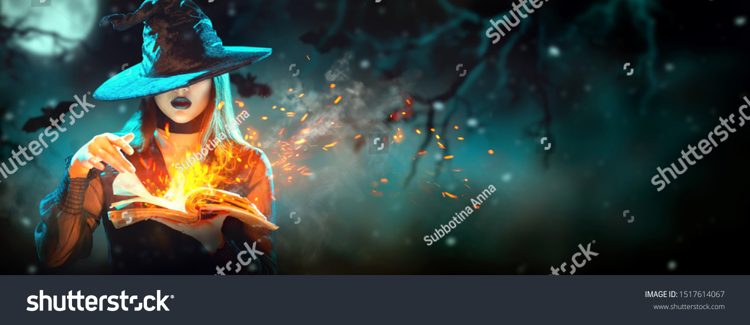 Halloween Witch girl with magic Book of spells portrait. Beautiful young woman in witches hat conjuring, making witchcraft. Over spooky dark magic forest background. Wide Halloween party art design #1517614067
