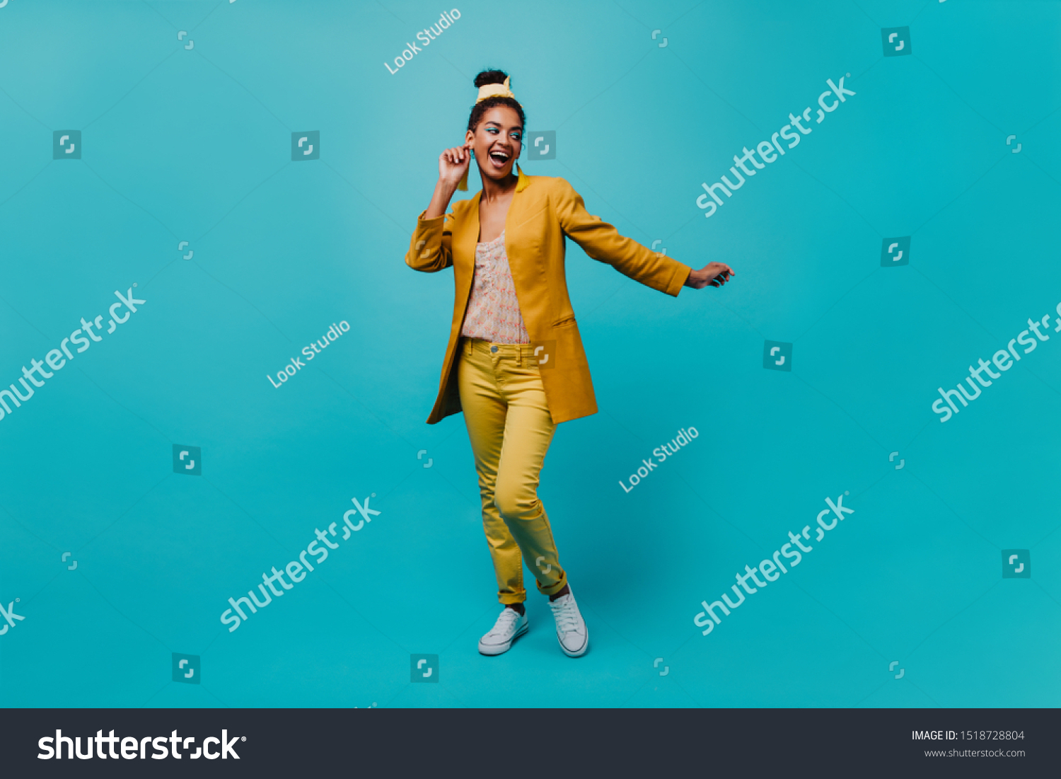 Full-length portrait of jocund black woman with casual hairstyle. Joyful african girl dancing on blue background. #1518728804
