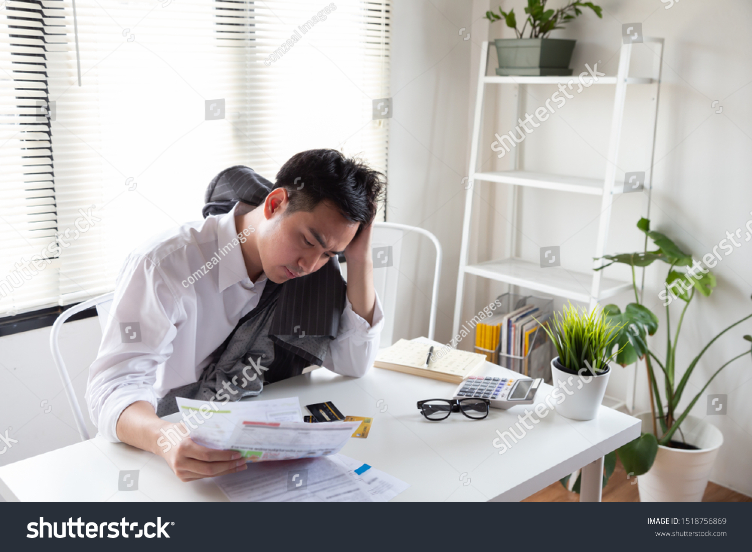Sad confused and stressed of young Asian man holding bills letter of credit card debt, Financial money problem and tax invoice notification concept #1518756869