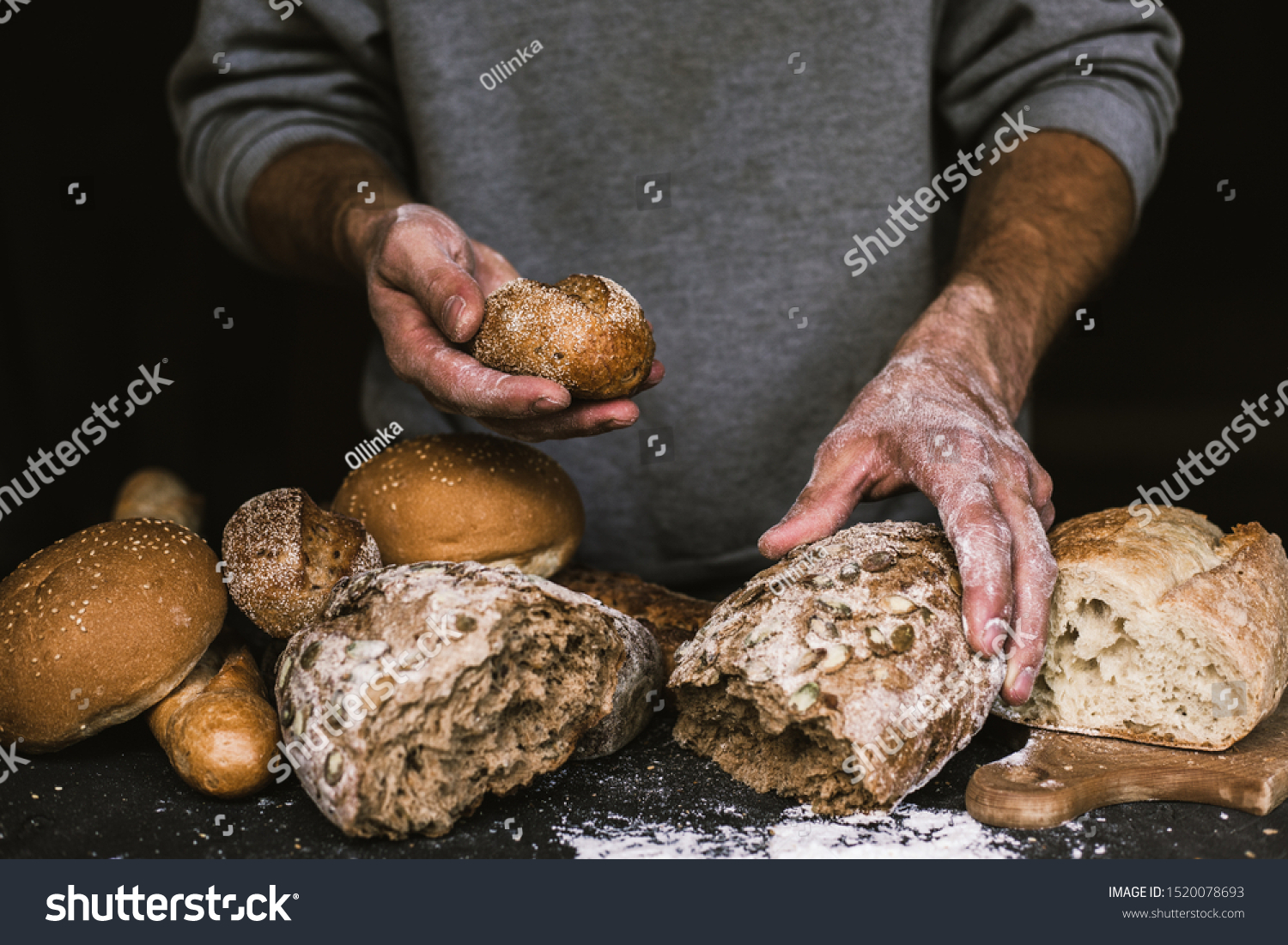 Baker man holding a rustic organic loaf of bread in his hands #1520078693