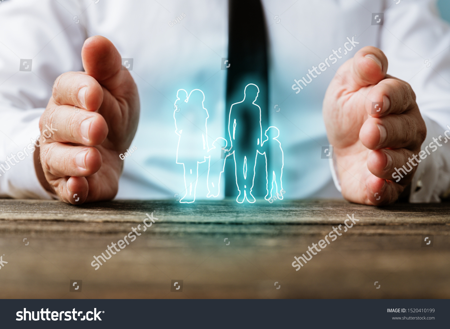 Glowing silhouette of a family on virtual interface with male hands making protective gesture around it in a conceptual image. #1520410199