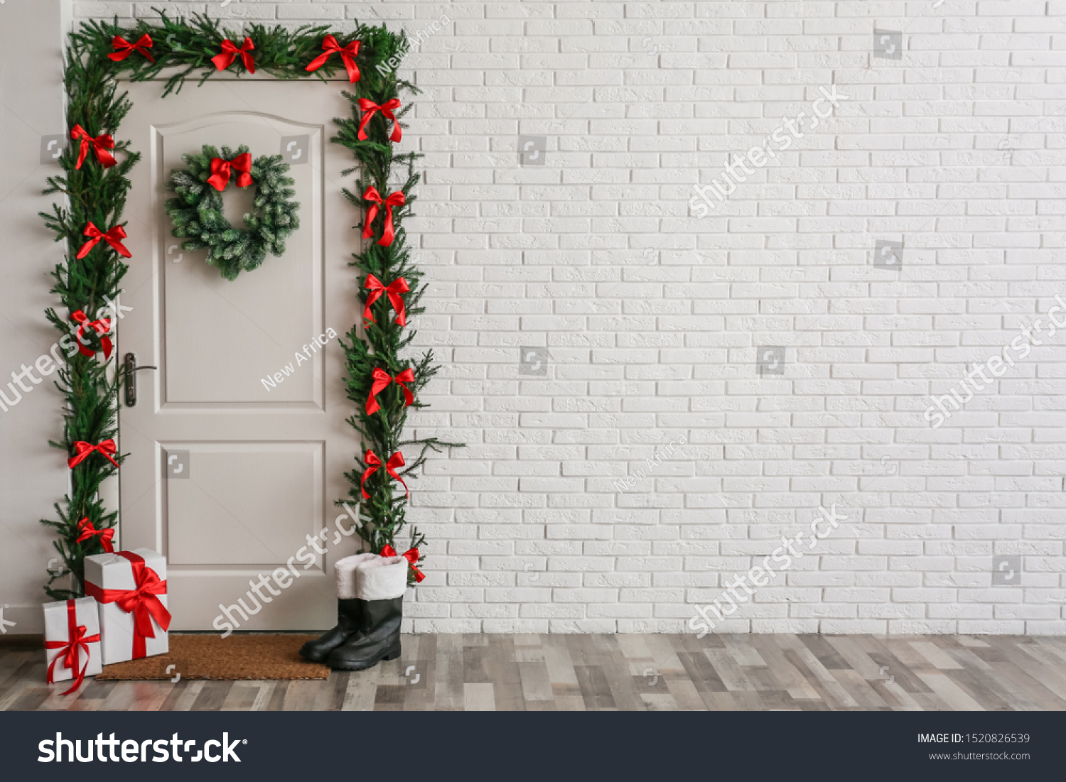 Stylish hallway interior with decorated door and Christmas gifts, space for text #1520826539