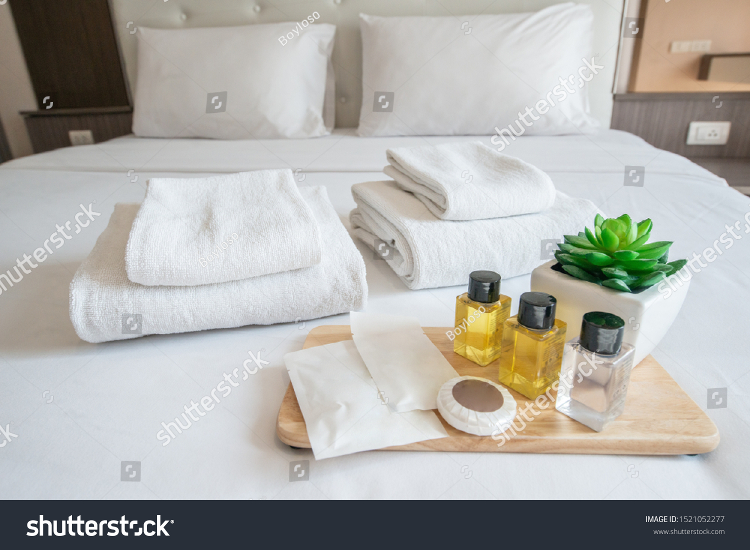Set of hotel amenities (such as towels, shampoo, soap, gel etc) on the bed. Hotel amenities is something of a premium nature provided in addition to the room when renting a room. #1521052277