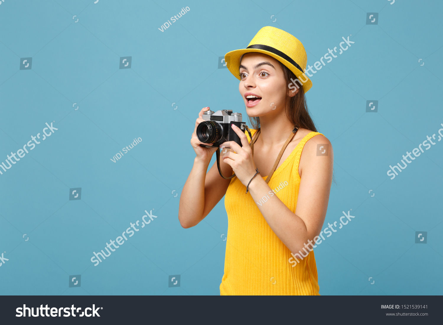 Traveler tourist woman in yellow summer casual clothes, hat with photo camera isolated on blue background. Female passenger traveling abroad to travel on weekends getaway. Air flight journey concept #1521539141