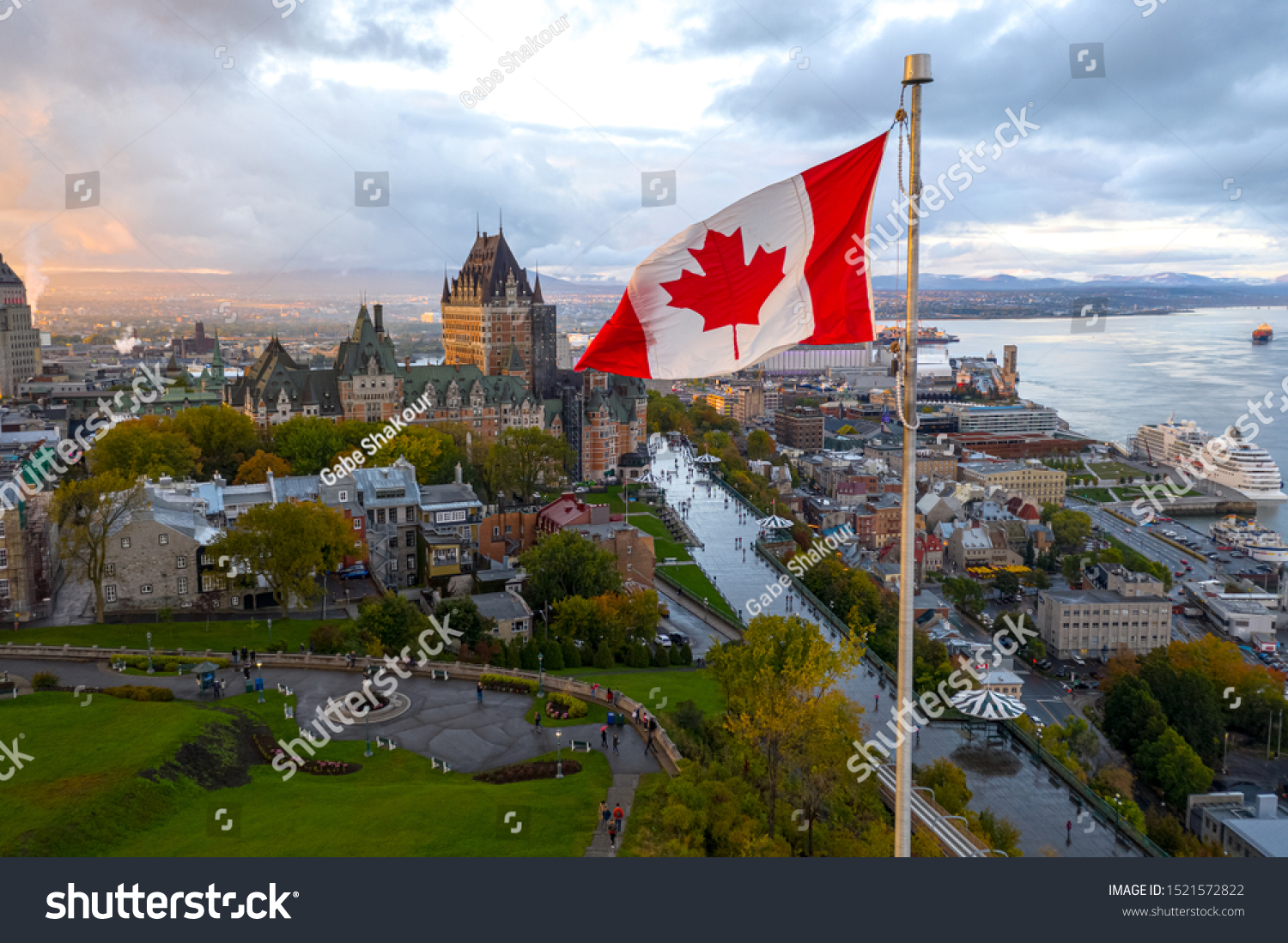 A Canadian flag flies high at sunset with Old Quebec City, Canada and the Saint Lawrence seaway in the background #1521572822