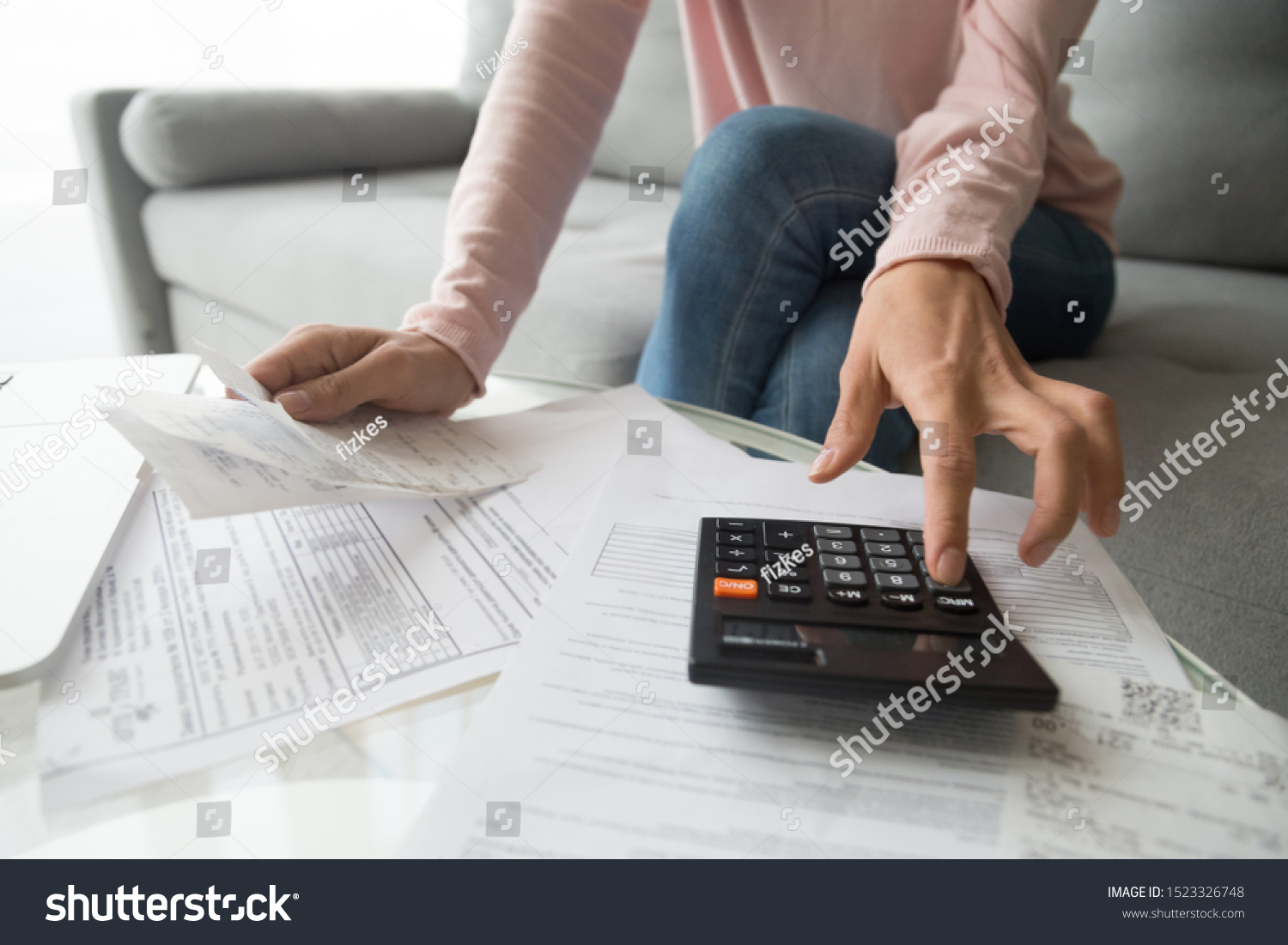 Woman renter holding paper bills using calculator for business financial accounting calculate money bank loan rent payments manage expenses finances taxes doing paperwork concept, close up view #1523326748