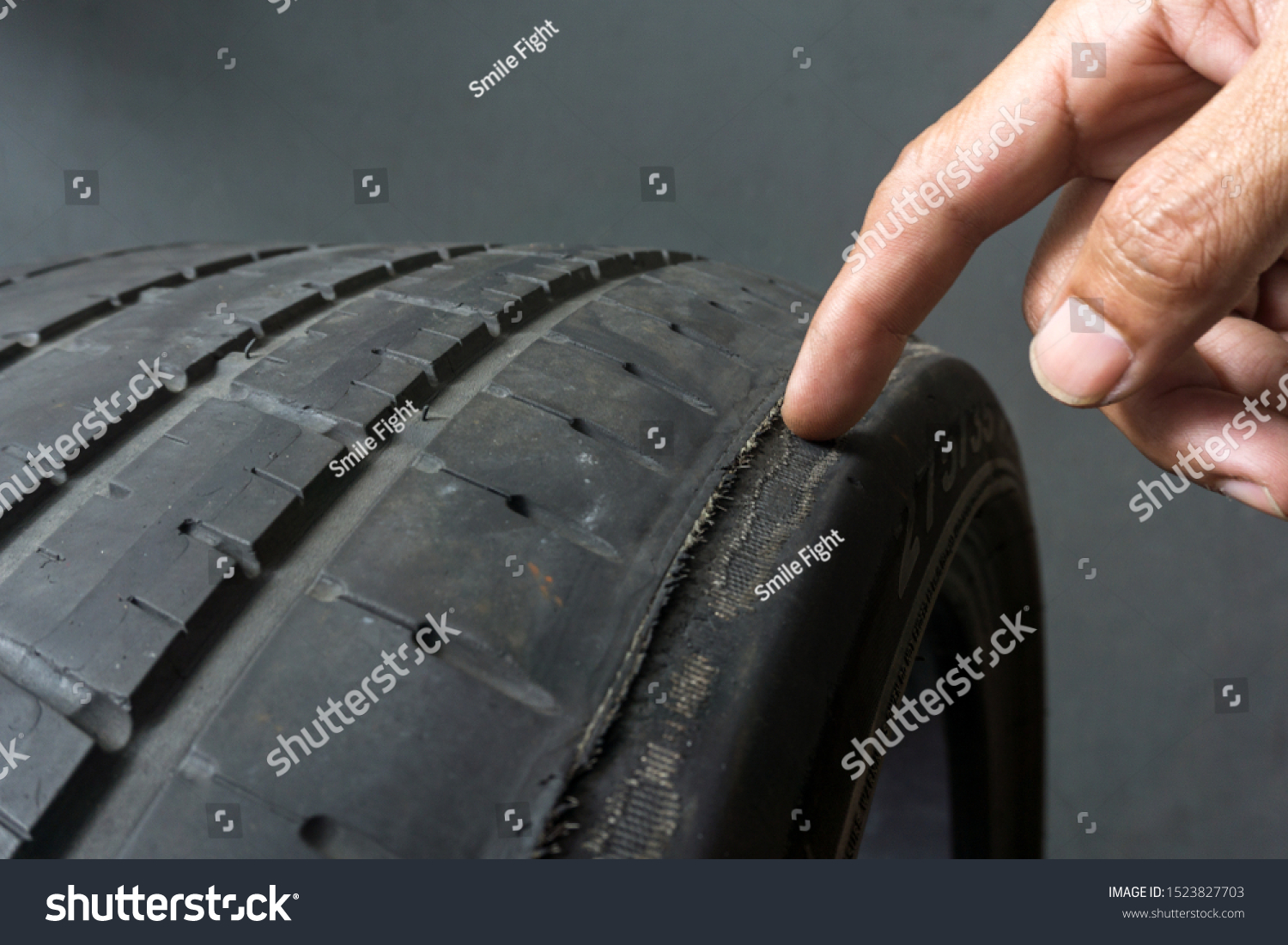 Finger pointing to damage on tire tread. Tire tread problems by tire pressure improper, Wheel alignment #1523827703