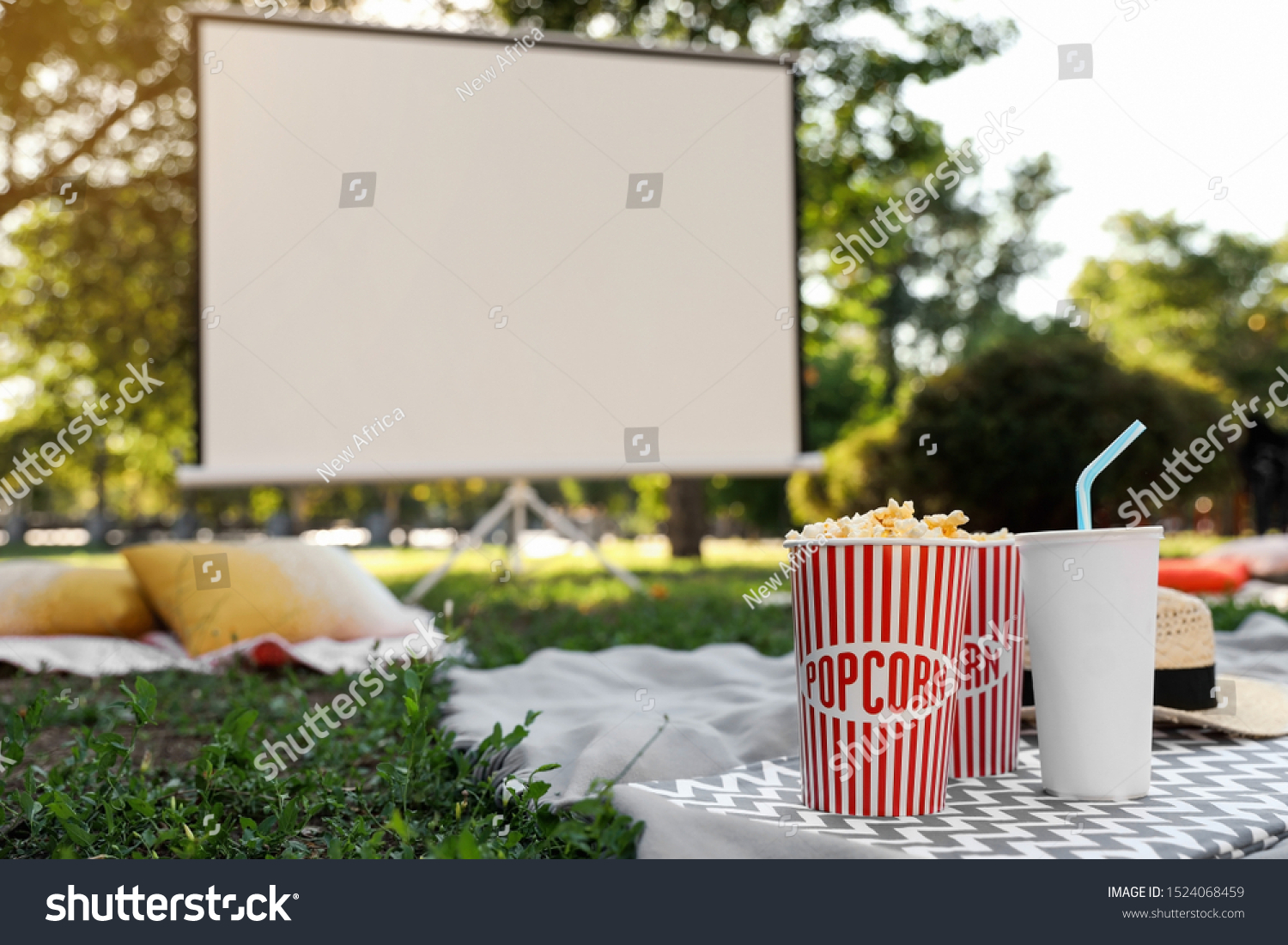 Popcorn and drink on green grass in open air cinema. Space for text #1524068459