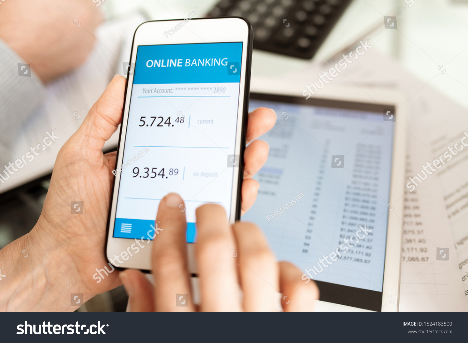 Hands of businessperson holding smartphone while scrolling through online banking account by workplace #1524183500