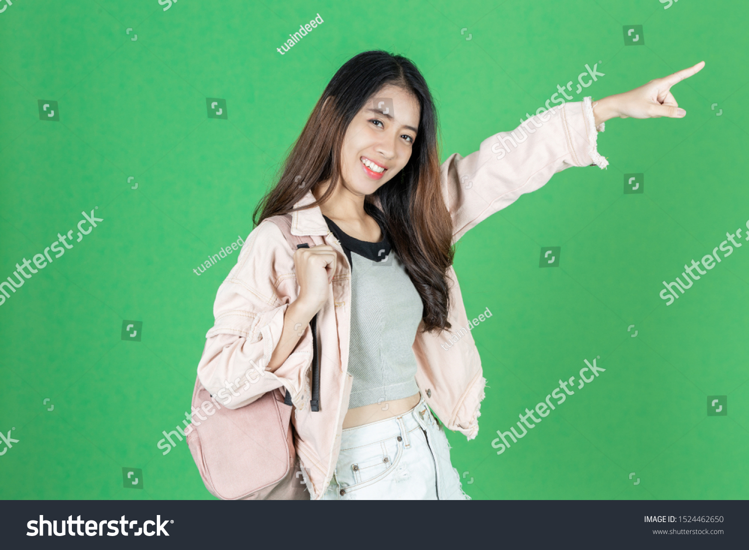 Attractive young Asian tourist girl with bag ready to travel over green isolated background. #1524462650