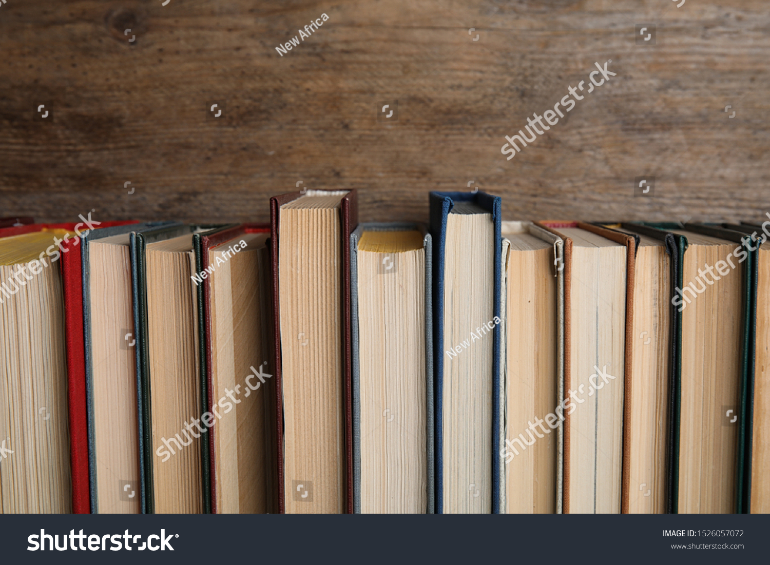 Stack of hardcover books on wooden background #1526057072