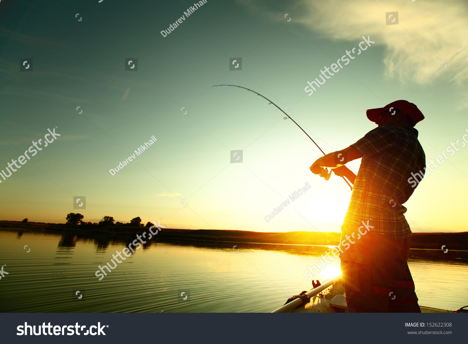 Young man fishing on a lake from the boat at sunset #152622308