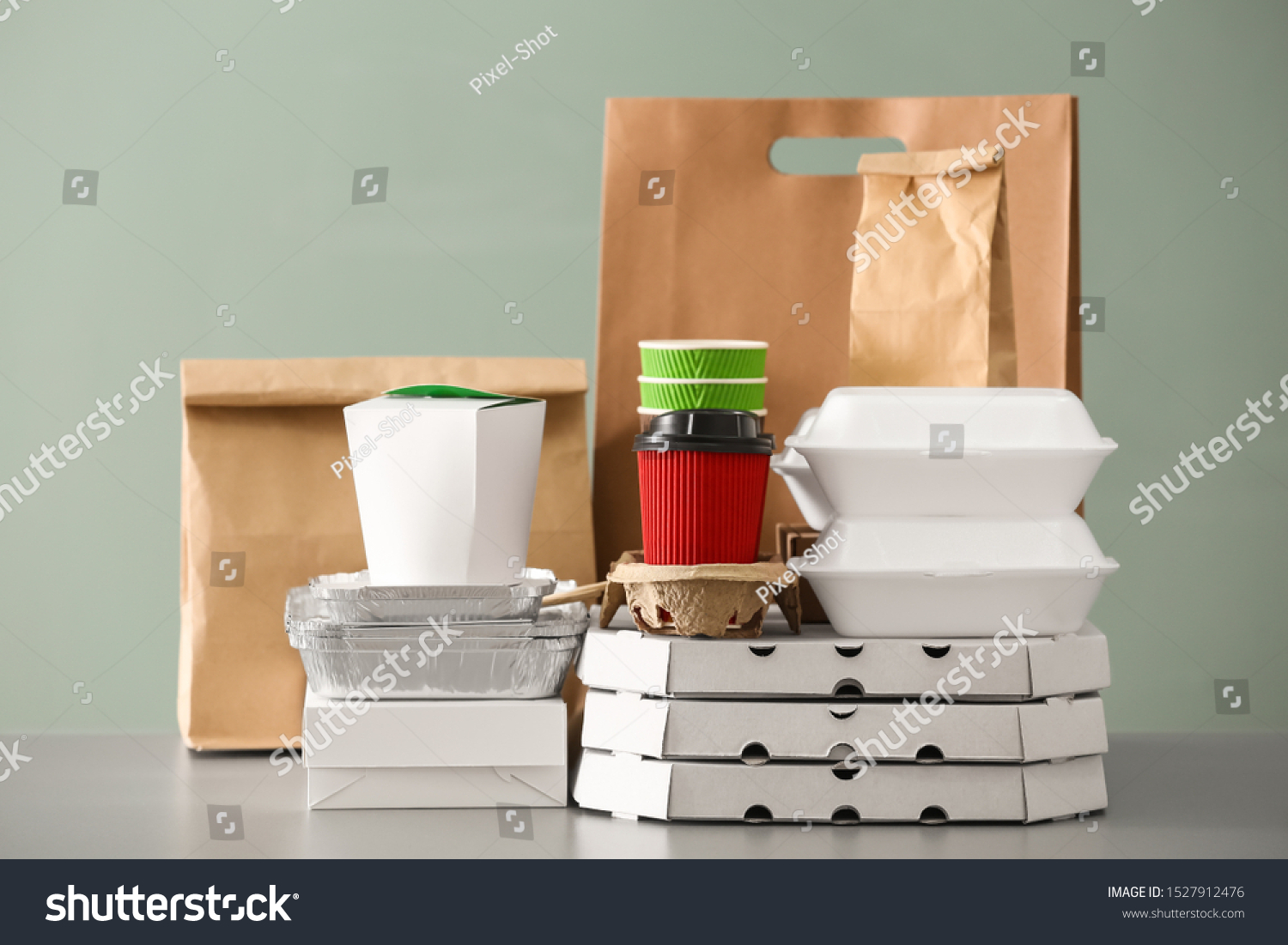 Different packages on table against color background. Food delivery service #1527912476