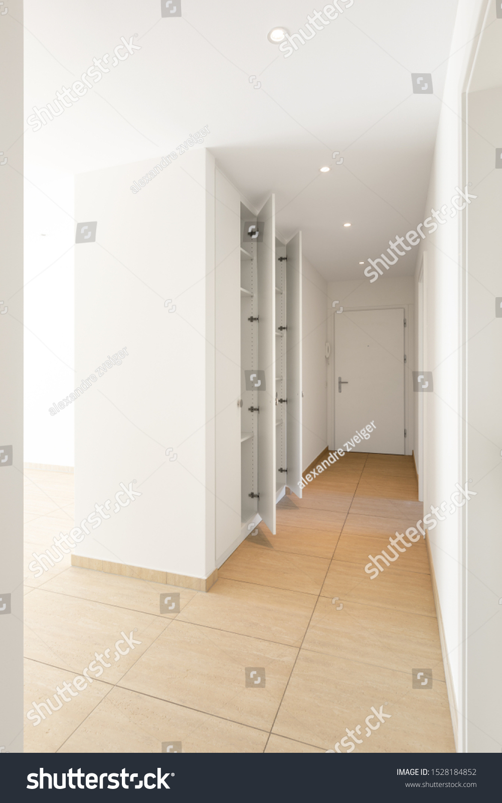 Corridor with travertine floor, white walls and built-in wardrobes. Nobody inside #1528184852