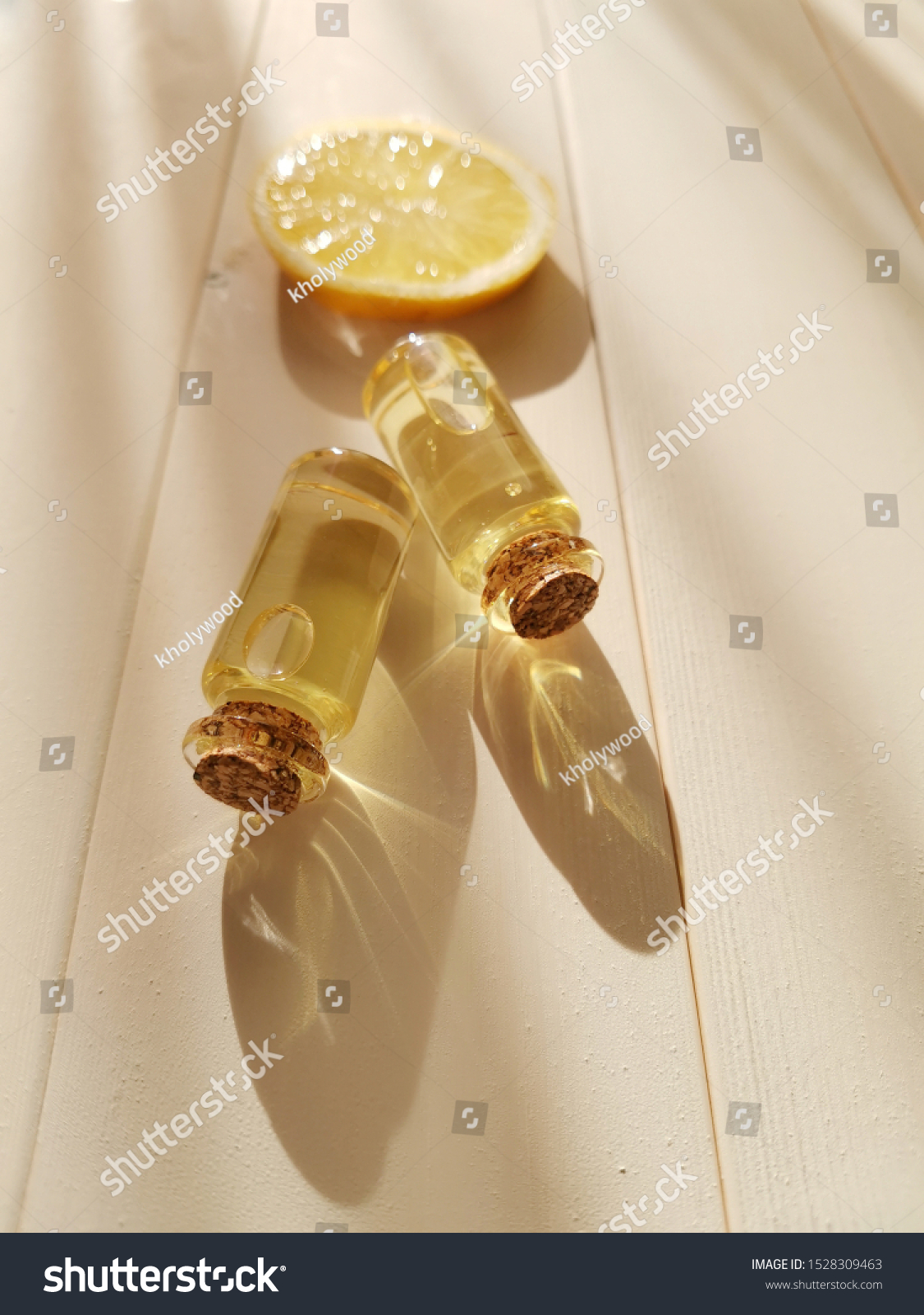 The concept of aromatherapy, relaxation, organics. Transparent bottles with essential oil, lemon on a light wooden background. Organic apothecary. Place for text. Minimalism, top view, flat lay. #1528309463