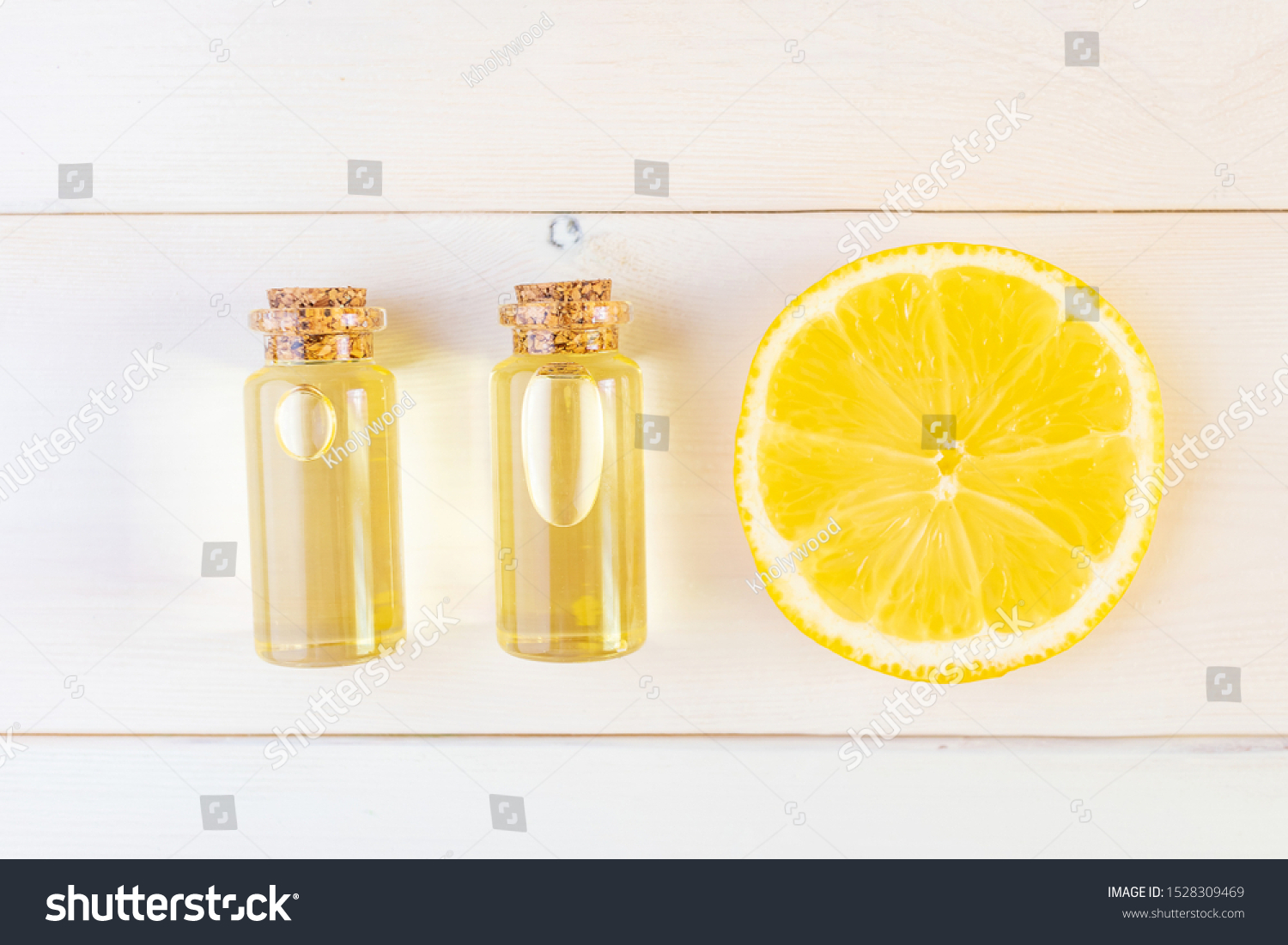 The concept of aromatherapy, relaxation, organics. Transparent bottles with essential oil, lemon on a light wooden background. Organic apothecary. Place for text. Minimalism, top view, flat lay. #1528309469