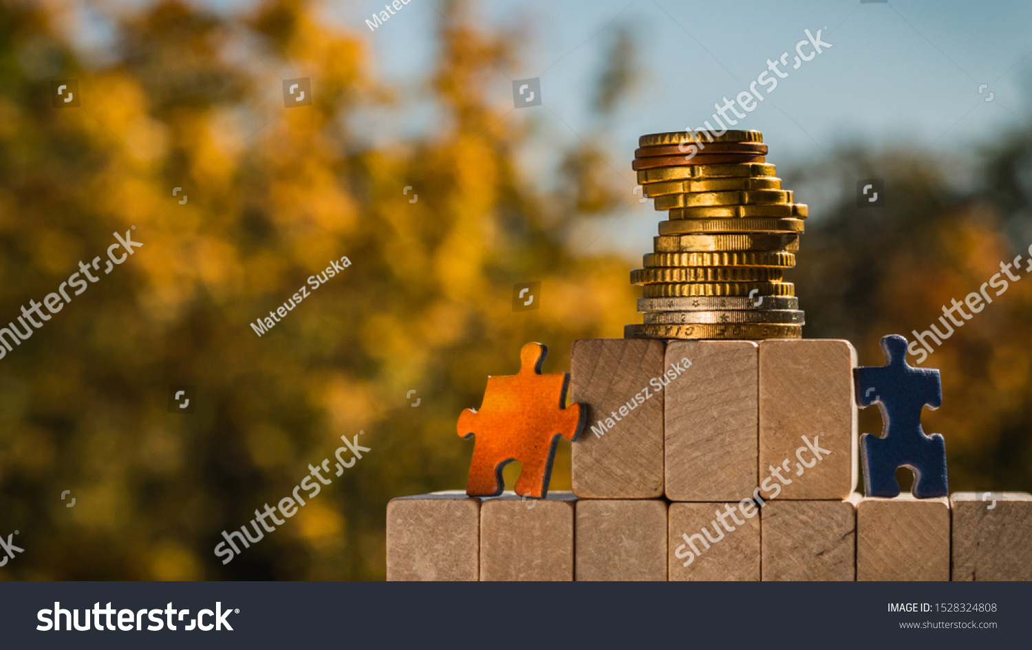 Several puzzles climb to the top of the pyramid made of wooden blocks. The concept of achieving business goals and reaching new levels of promotion. #1528324808