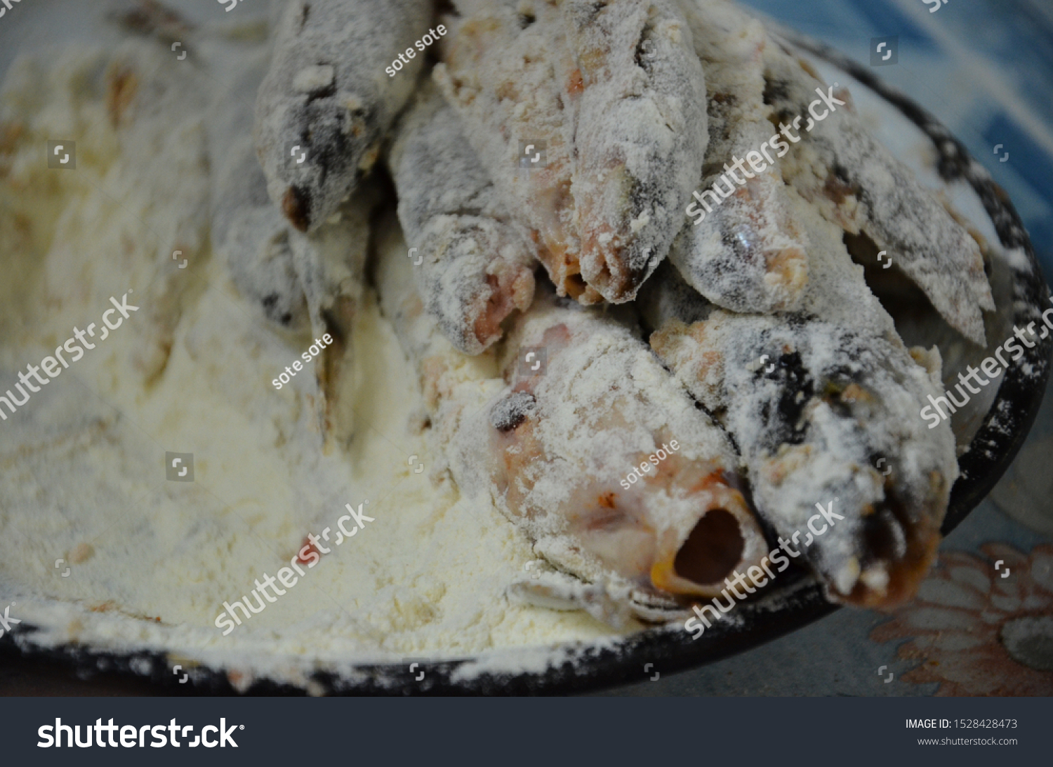 Couple of small river fish covered with flour before putting them in the fraying pan #1528428473