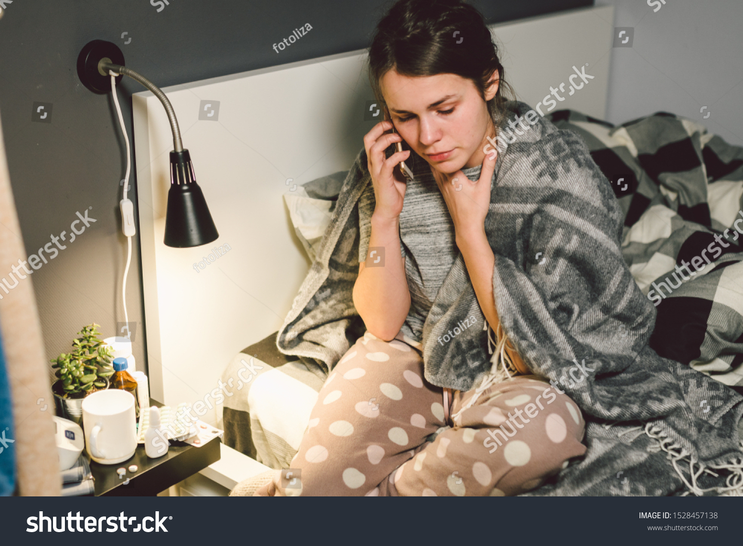 respiratory diseases and home remedies. young woman sick with cold sitting bedroom on bed holding throat sadness emotion. Sore throat man takes pills. Call phone, ask for help doctor. Call ambulance. #1528457138