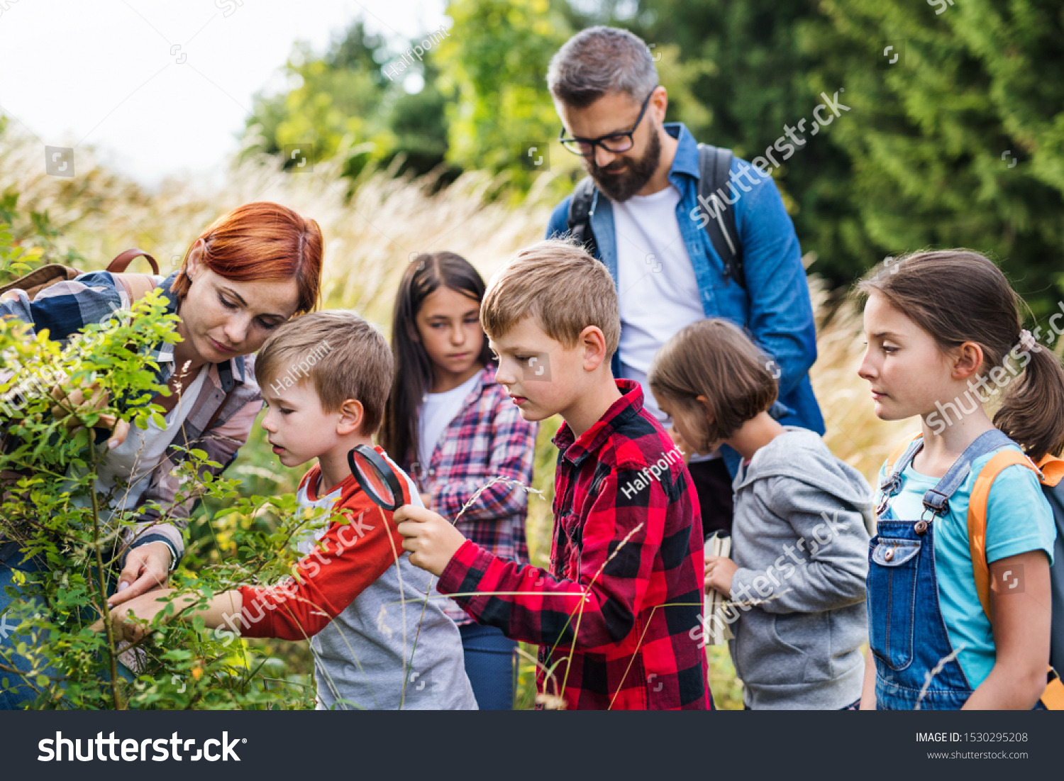 Group of school children with teacher on field trip in nature, learning science. #1530295208