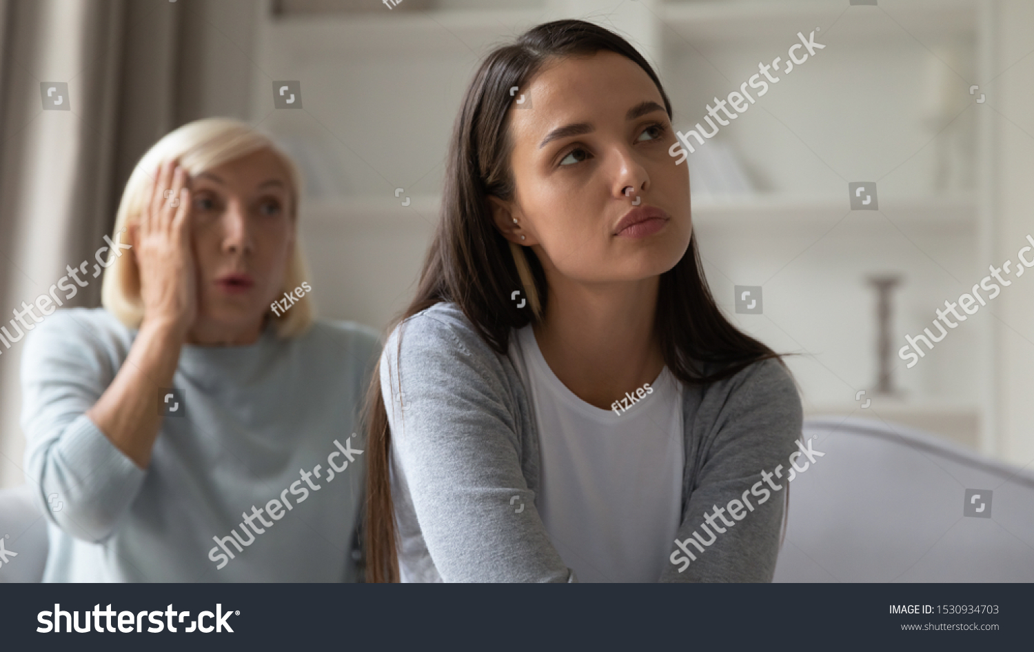 Head shot unhappy stressed young woman tired from mature mothers lecturing. Upset grown up daughter ignoring moralizing middle aged mommy, turning with back to her. Generations gaps concept. #1530934703