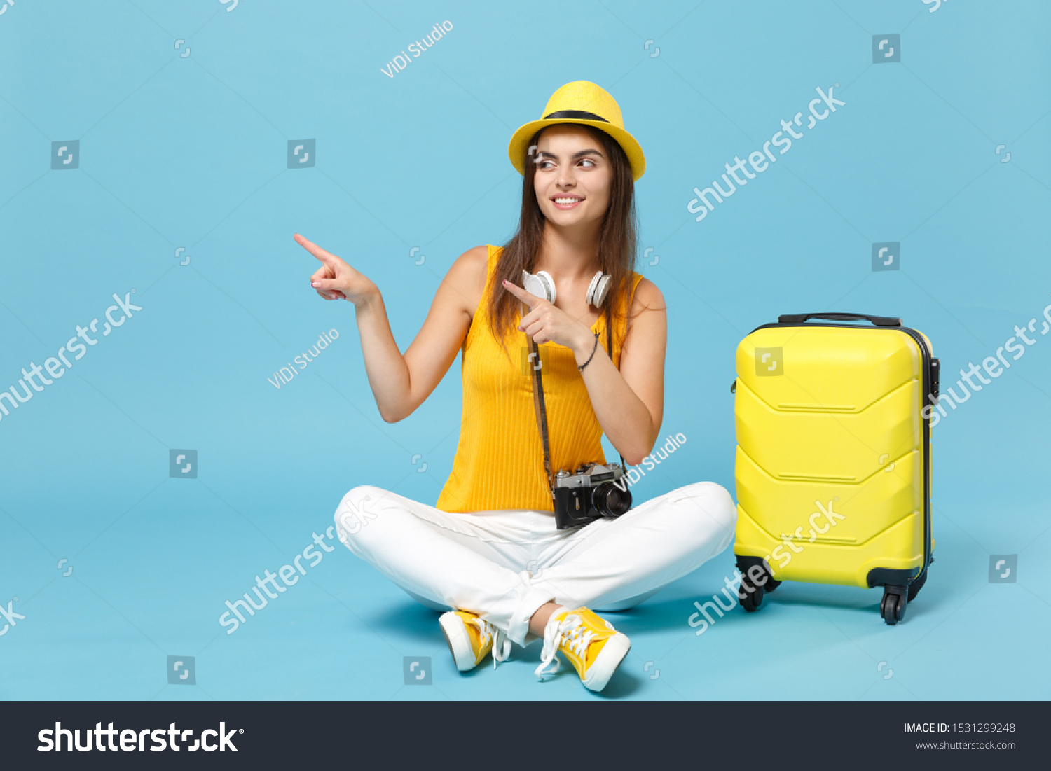 Traveler tourist woman in yellow casual clothes hat with suitcase photo camera isolated on blue background. Female passenger traveling abroad to travel on weekends getaway. Air flight journey concept #1531299248