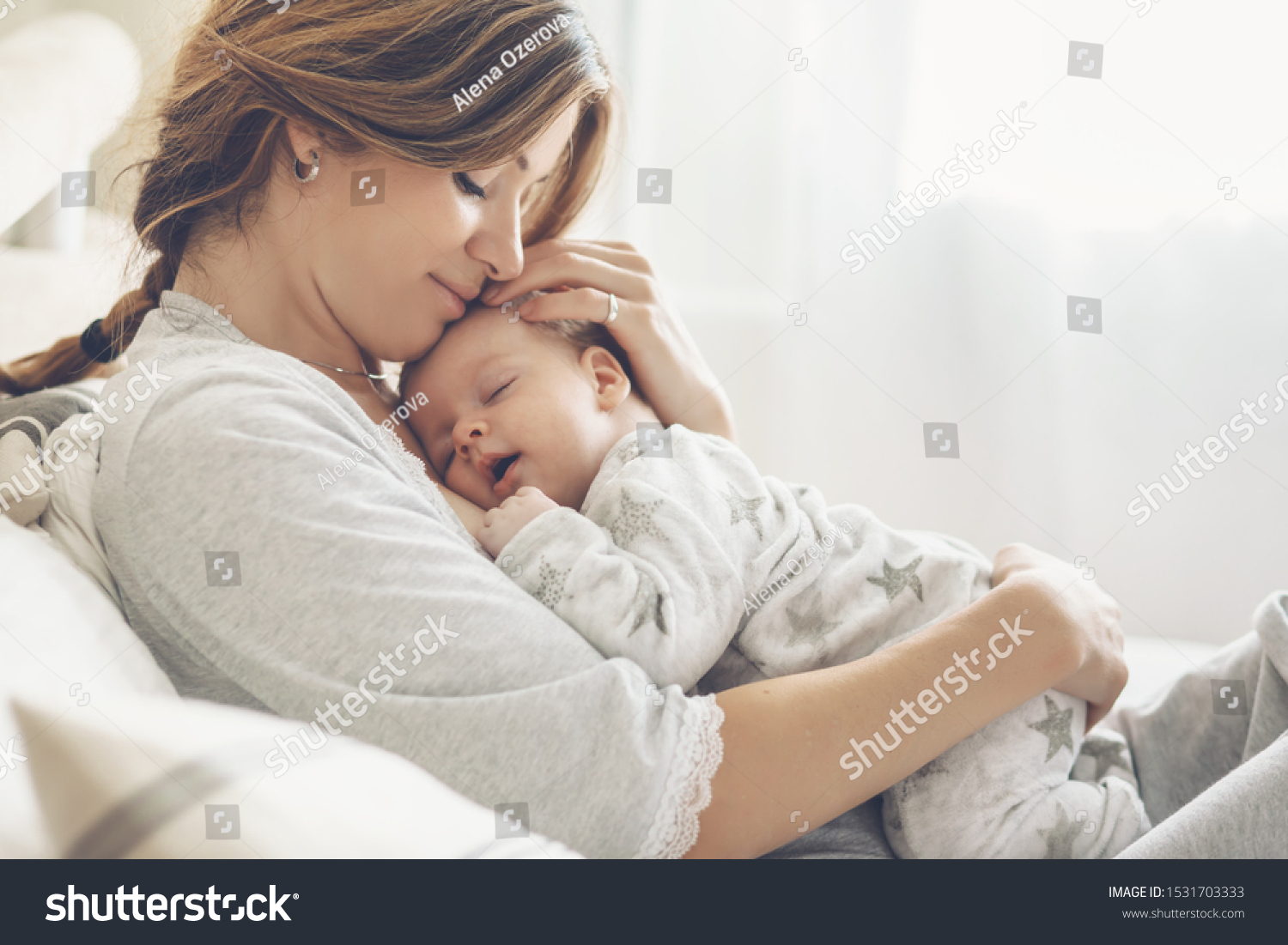 Loving mom carying of her newborn baby at home. Bright portrait of happy mum holding sleeping infant child on hands. Mother hugging her little 2 months old son. #1531703333