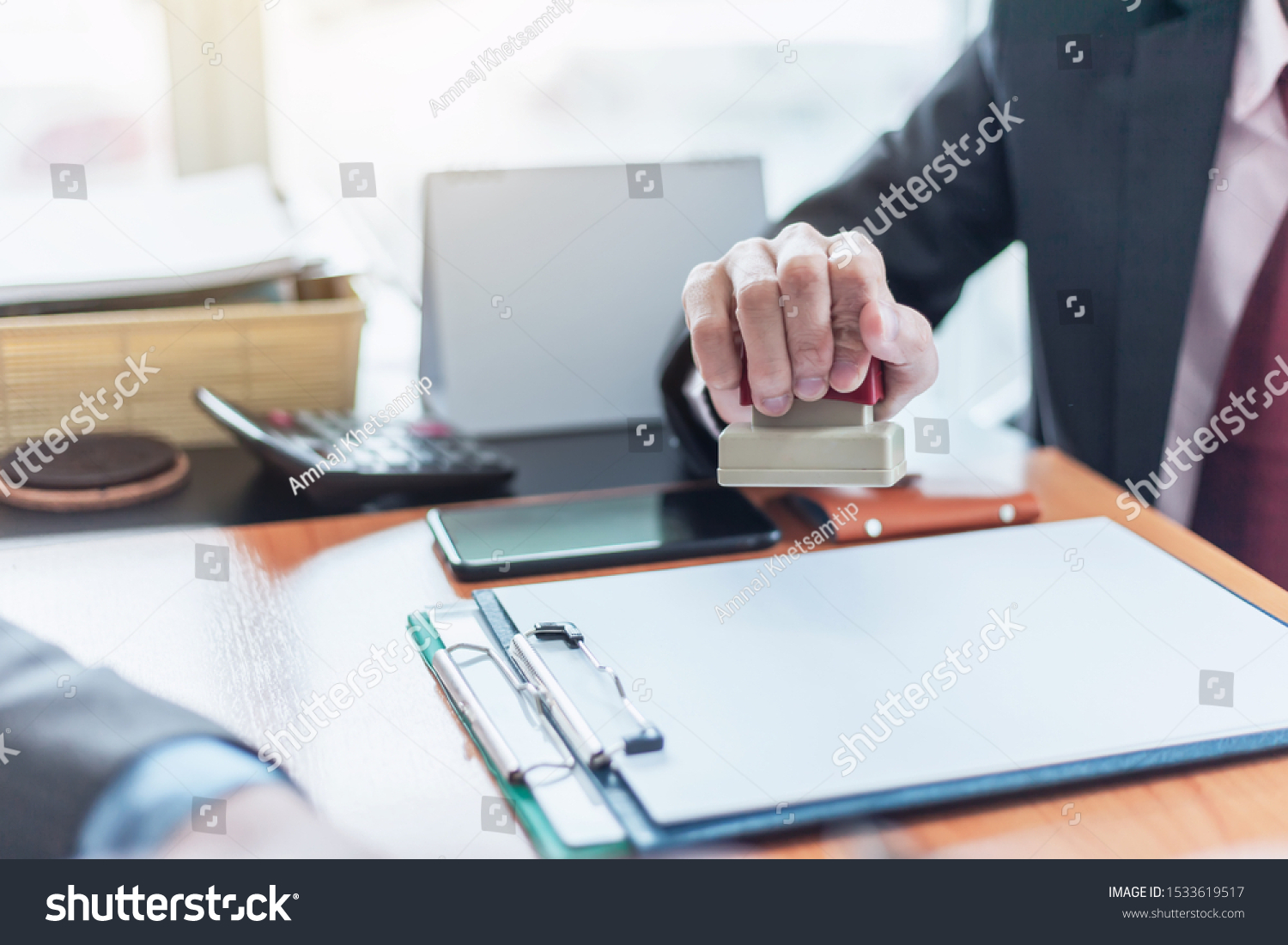 Businessman stamping with approved stamp on document at office. #1533619517