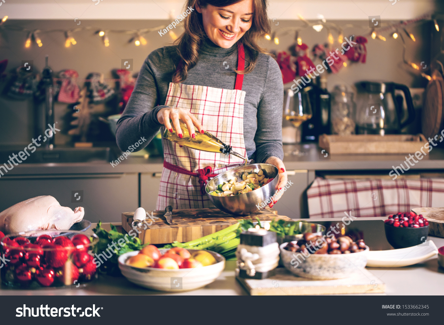 Young Woman Cooking in the kitchen. Healthy Food for Christmas (stuffed duck or Goose) #1533662345