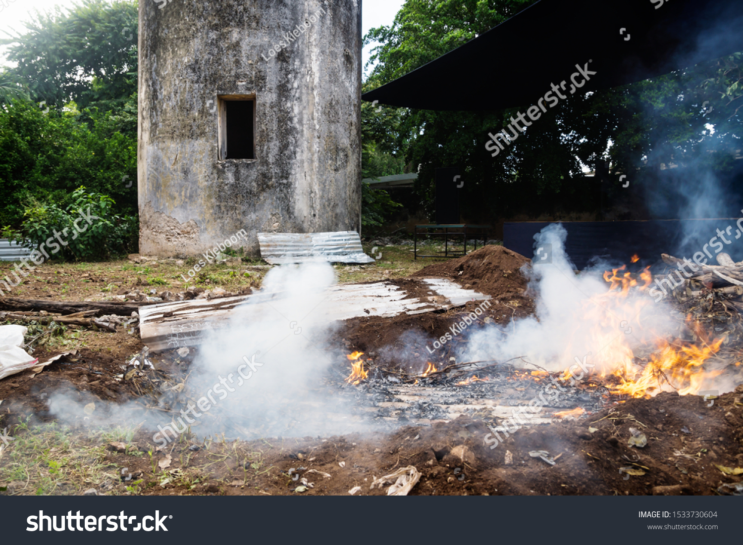 Wood burning underground stove with smoke for cooking traditional Mexican dish Pibes made for day of the dead in Merida, Mexico #1533730604