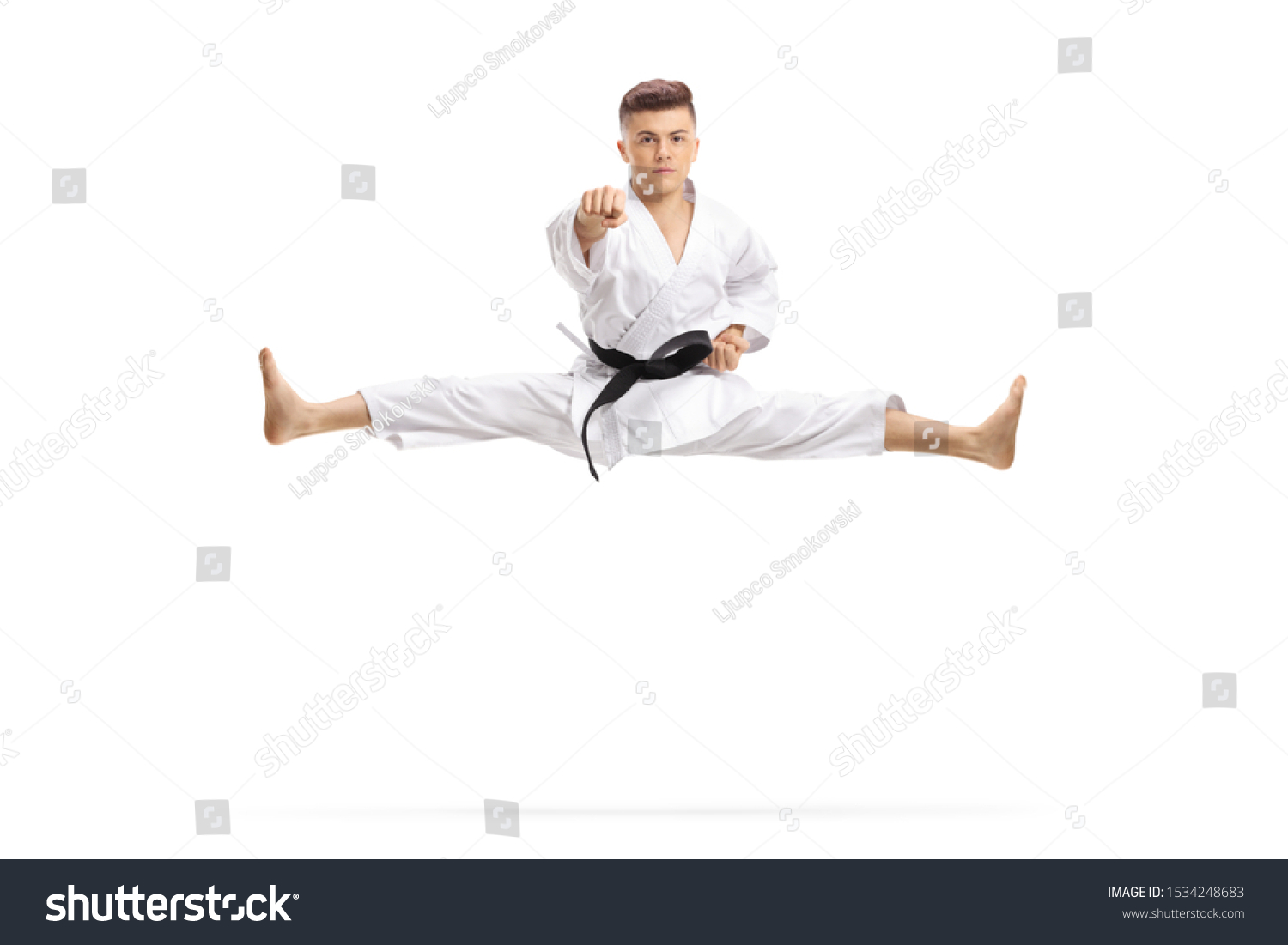 Guy in kimono jumping and doing martial art split isolated on white background #1534248683