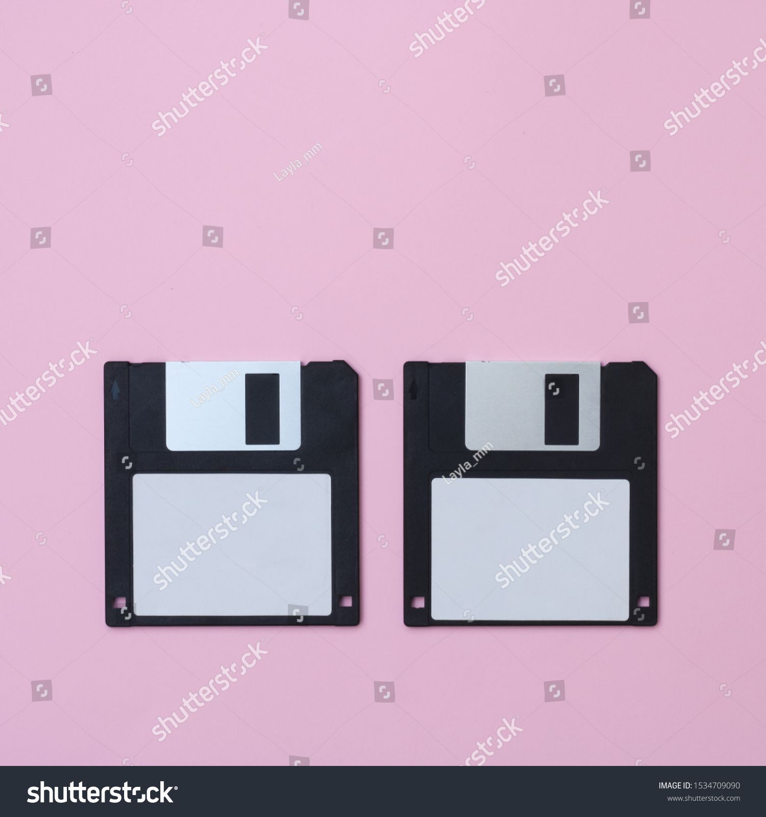 Two black floppy disks on a pink background. #1534709090